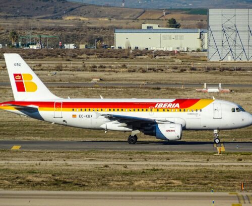 white and red Iberia airlines plane parked on runway